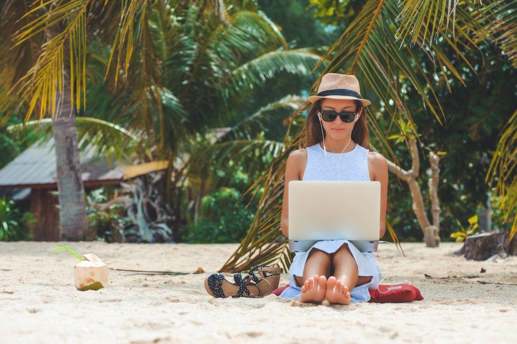 Digitálna nomádka pracujúca na pláži